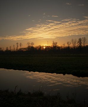 Zonsondergang Nederlandse polder met reflectie van Jochem van der Meer