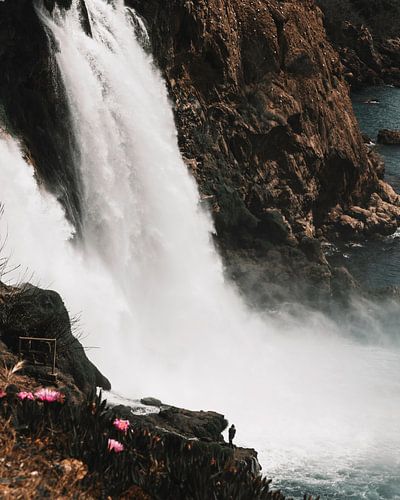 Man at the foot of the waterfall