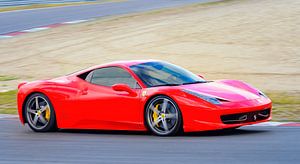 Sportwagen Ferrari 458 Italia fährt schnell auf der Rennstrecke