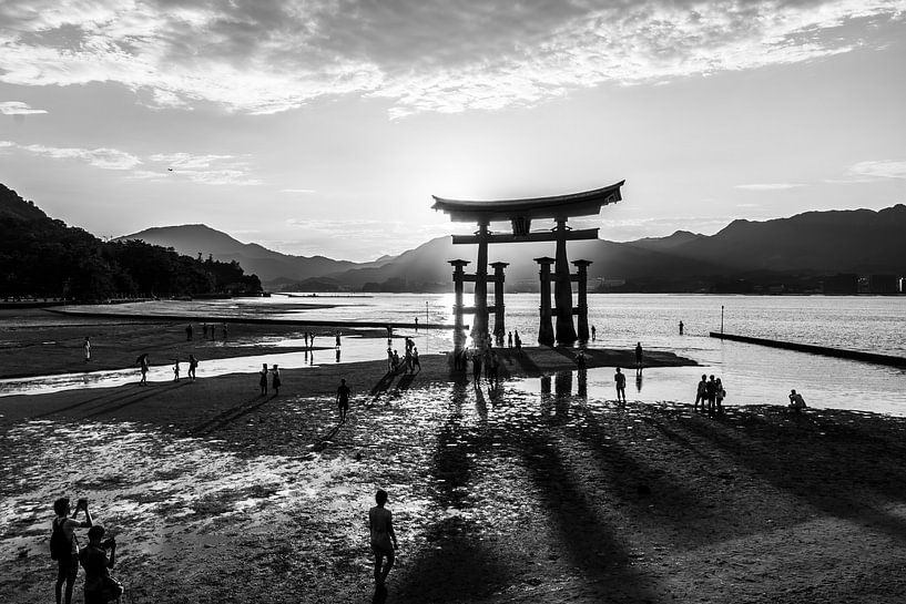 A giant wooden holy gate stands pontifically in low water while the undergoing sun hides behind it by Jan Willem de Groot Photography