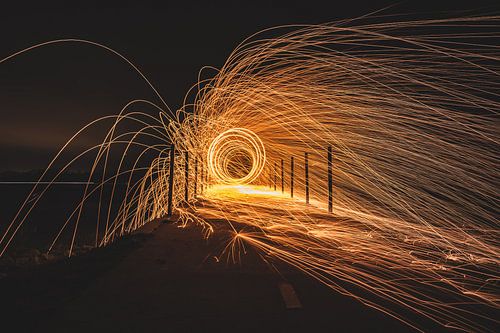 Rotating steel wool with sparkling burning sparks in the night with long exposure shutter photograph