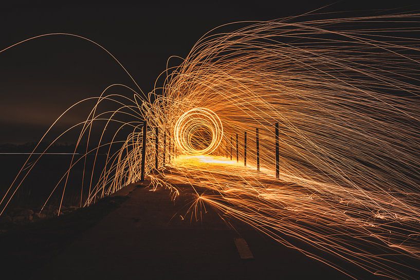 Rotating steel wool with sparkling burning sparks in the night with long exposure shutter photograph by Fotografiecor .nl
