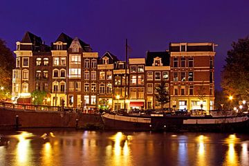 Traditionele middeleeuwse huizen aan de Amstel in Amsterdam bij nacht by Eye on You