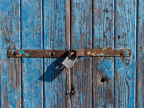 Verweerde blauwe deur met roestig hangslot in Cagliari