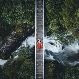 Bridge over flowing water woman with red dress by Daniel Kogler