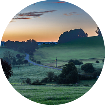 Kleurige zonsopgang op een mistige morgen tussen de weilanden bij kasteel buesdaal