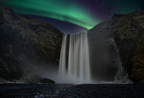 Skogafoss waterval met noorderlicht in IJsland