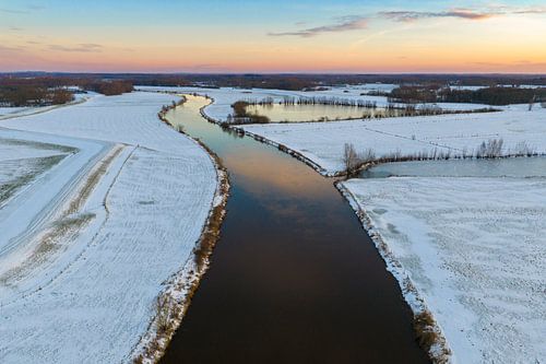 De Vecht stroomt door een besneeuwd winterlandschap tijdens zonnige dagen.