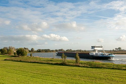 Vrachtship vaart langs de Ijssel
