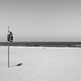 Eenzaam figuur op een verlaten strand van Reis Genie