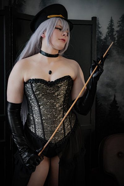 Een jonge dominatrix met een stok in haar hand van Denny Gruner