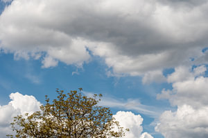 Een blauwe lucht met grijze en witte wolken