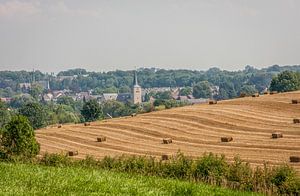 Blick über Simpelveld mit Kirche und Strohballen von John Kreukniet