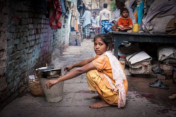 Indiaas meisje doet de afwas in de achterbuurt straten van Varanasi  in India. Wout Kok One2expose