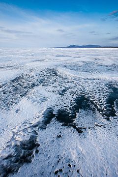 Zigzag van transparant blauw-turquoise ijsblauwe lucht en heuvels op het Baikalmeer van Michael Semenov