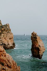 Typische Algarve-Felsen mit Segelboot in der Ferne von Renate Smit Photography