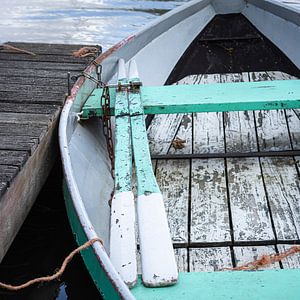 Nostalgisch oud roeibootje met roeispanen in aquablauw