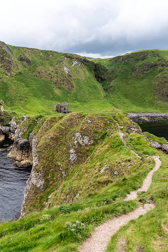 Green coastline with castle ruins
