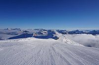 Skipiste in Kitzbühel, Tirol (Oostenrijk) omringd door bergtoppen en bewolking