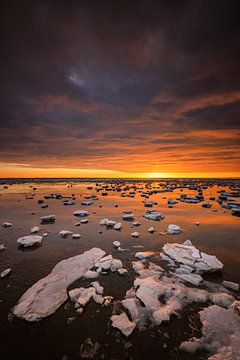 De Waddenzee is bedekt met IJsschotsen in de winter. Een mooie zonsondergang geeft prachtige kleuren van Bas Meelker