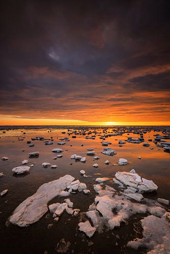 De Waddenzee is bedekt met IJsschotsen in de winter. Een mooie zonsondergang geeft prachtige kleuren