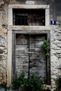 Dubbele houten deur met hangslot en huisnummer