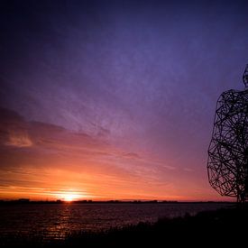 Ondergaande zon bij Lelystad bij de Denkende Man van Peter de Jong