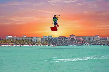 Un cerf-volant de surf saute sur Palm Beach à Aruba avec le coucher du soleil sur Eye on You