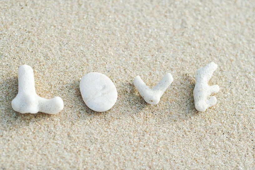 LP 70505953 Coral pieces that spell the word love on the beach by BeeldigBeeld Food & Lifestyle