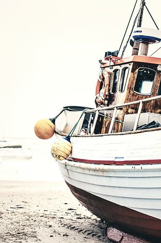 Oude vissersboot ligt aan de Noordzeekust