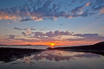gebrande blauw-roze lucht en stenen boven het kalme water van de baai in kareia scandinavië