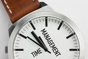Makroaufnahme einer modernen Metalluhr mit dem Text Time Management auf dem Zifferblatt