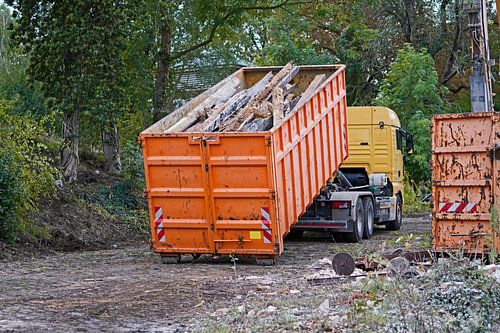 Vrachtwagen op een bouwplaats die een container oppikt