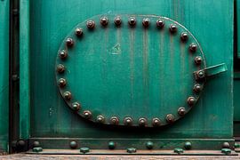 Green panel of a train, with bolts and nuts by Jenco van Zalk