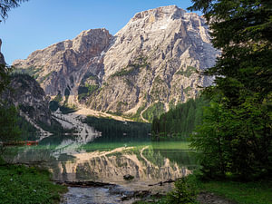 Der türkisfarbene Pragser Wildsee liegt ruhig eingebettet zwischen den steilen Felswänden der Dolomiten. Spiegelglattes Wasser