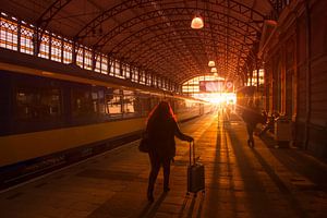 Silhouettes de voyageurs à la gare pendant le coucher du soleil