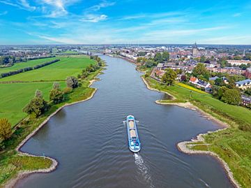 Vrachtschip varend op de rivier de IJssel bij Zutphen in Nederland van Eye on You