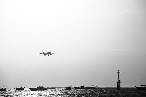 Landend vliegtuig boven zee tijdens zonsondergang High Key sur Chantal Schutte