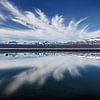 Landschap met weerspiegeling van bergen en wolken in een meer van Chris Stenger