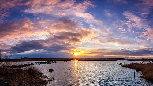 Sunset over water with pink clouds in De Onlanden by R Smallenbroek