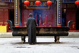 Praying woman in a Buddhist monastery by Henny Hagenaars