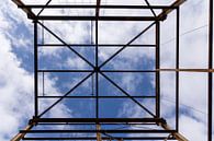 Urbex symmetrie- verroeste metalen constructie tegen een blauwe lucht met wolken van Photo Henk van Dijk thumbnail