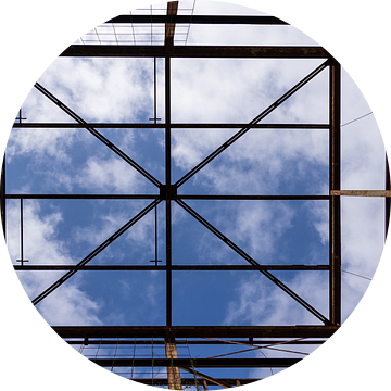 Urbex symmetrie- verroeste metalen constructie tegen een blauwe lucht met wolken van Photo Henk van Dijk
