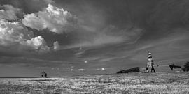 Das Brunnenhaus von Hindeloopen und die Kirche hinter dem Deich in Schwarz-Weiß von Harrie Muis