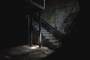 Licht inval op trap in donkere kelder van Danique Verkolf
