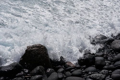 Brekende golven op lava stenen