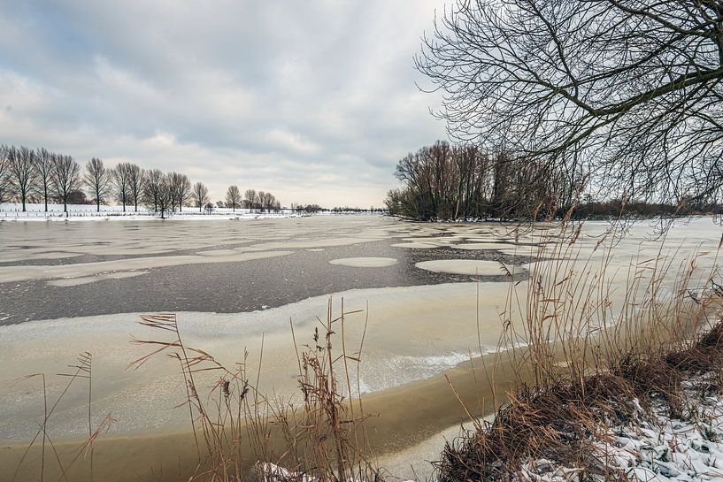 Winterlandschaft mit einem mit Eis und Schnee bedeckten See von Ruud Morijn