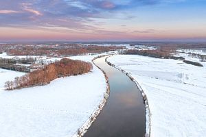 Die Vecht fließt durch eine verschneite Winterlandschaft bei Sonnenschein