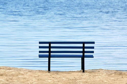 Blauwe bank met uitzicht op de blauwe zee