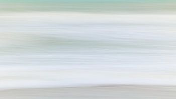 At the beach. Soft hues of the North Sea waves in the winter morning light. Aspect ratio 16:9
